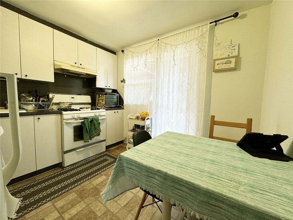 249 Bay 22nd Street Brooklyn, NY 11214 - Photo 9 of 12 a kitchen with a stove a sink and cabinets