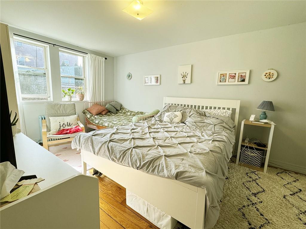 249 Bay 22nd Street Brooklyn, NY 11214 - Photo 10 of 12 a bed sitting in a bedroom next to a window