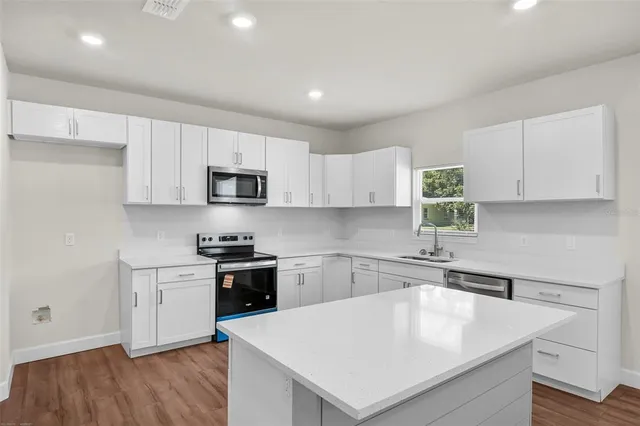 a kitchen with a sink a stove a microwave and cabinets