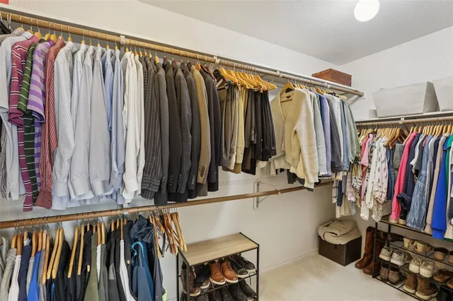 a view of walk in closet with clothes and shoes