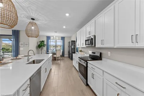 a large kitchen with stainless steel appliances granite countertop a sink and dishwasher a stove top oven with wooden floor