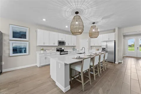 a kitchen with stainless steel appliances granite countertop a sink a stove and a wooden floors