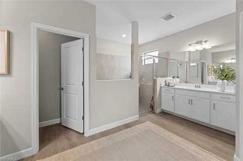 a spacious bathroom with a double vanity sink a mirror and a bathtub