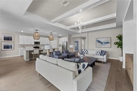 a living room with fireplace furniture and a view of kitchen