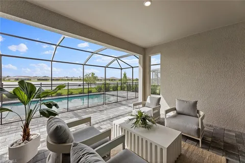 a living room with furniture and potted plants