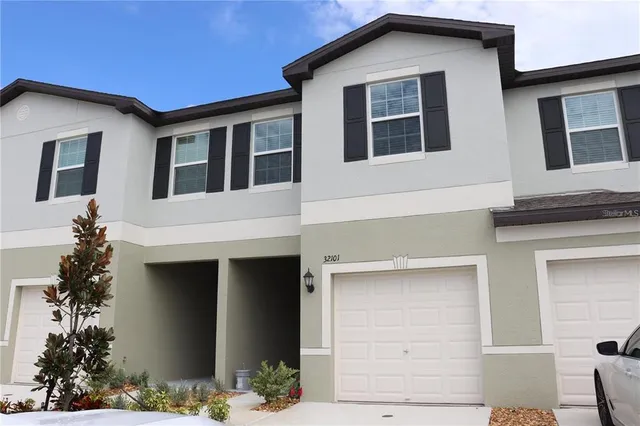 a front view of a house with plants