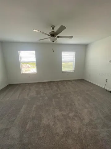 an empty room with a window and a ceiling fan