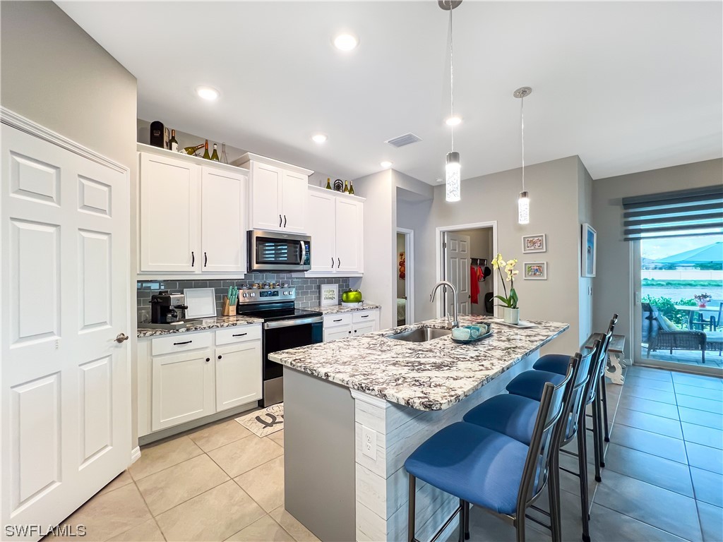 a kitchen with kitchen island granite countertop a sink and microwave