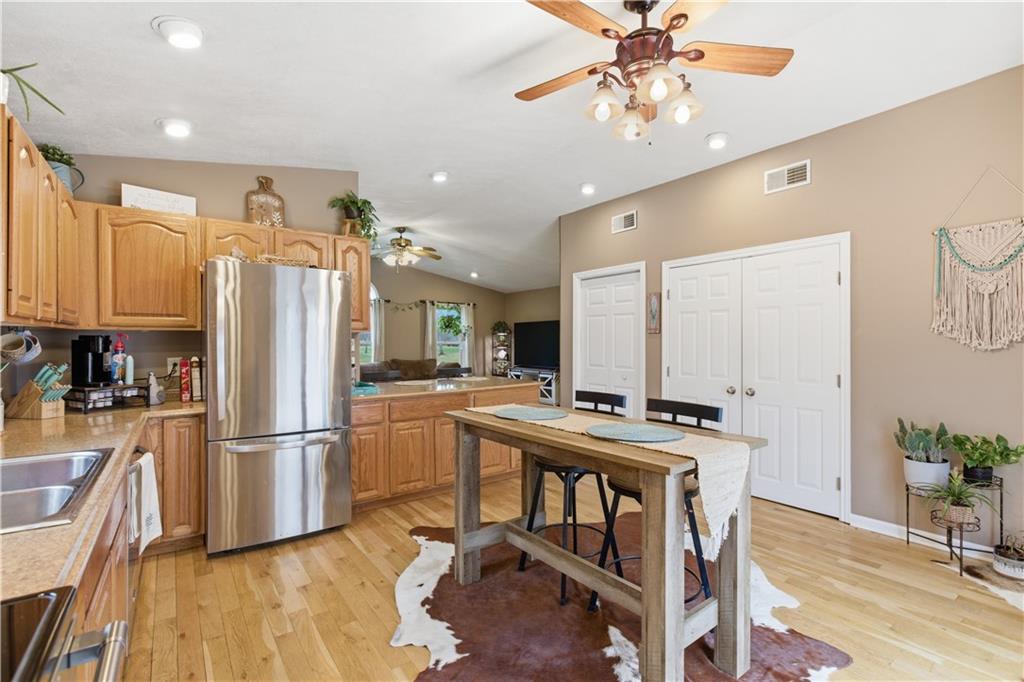 87 Broad Street Marianna, PA 15345 - Photo 11 of 37 a kitchen with kitchen island a stove a refrigerator and a dining table with wooden floor