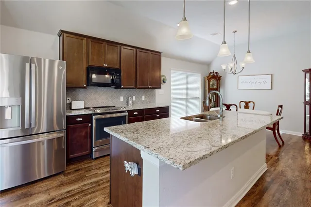 a kitchen with stainless steel appliances granite countertop a sink refrigerator and microwave