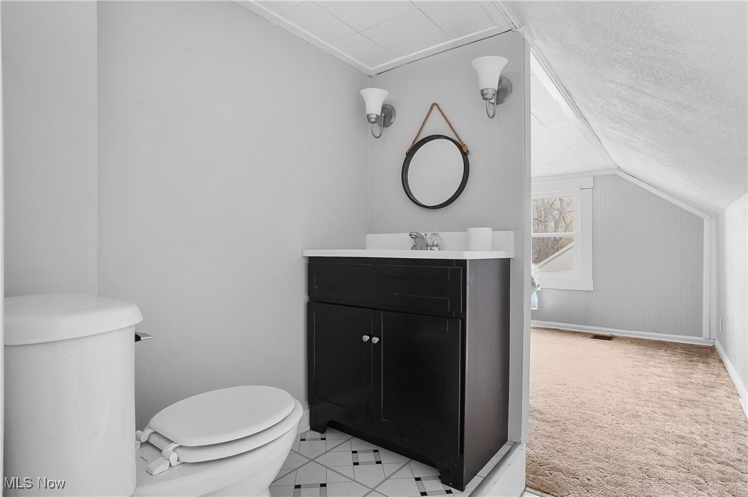 3206 9th Street Northwest Canton, OH 44708 - Photo 22 of 32 Bathroom featuring a textured ceiling, vanity, vaulted ceiling, and toilet