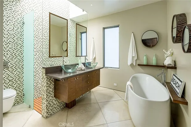 a bathroom with a tub a sink and a mirror