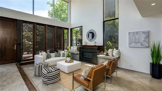 a living room with furniture a clock and a large window