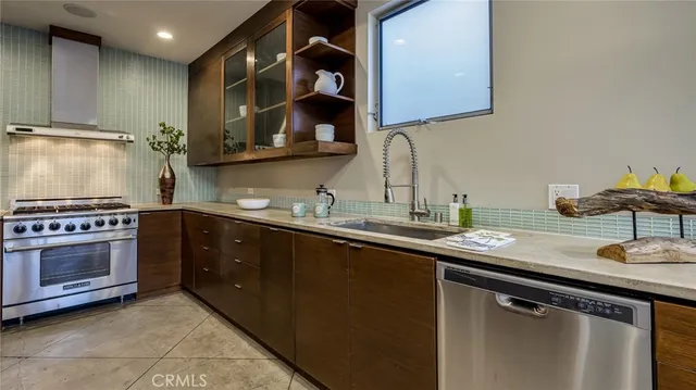 a kitchen with stainless steel appliances granite countertop a sink stove and cabinets