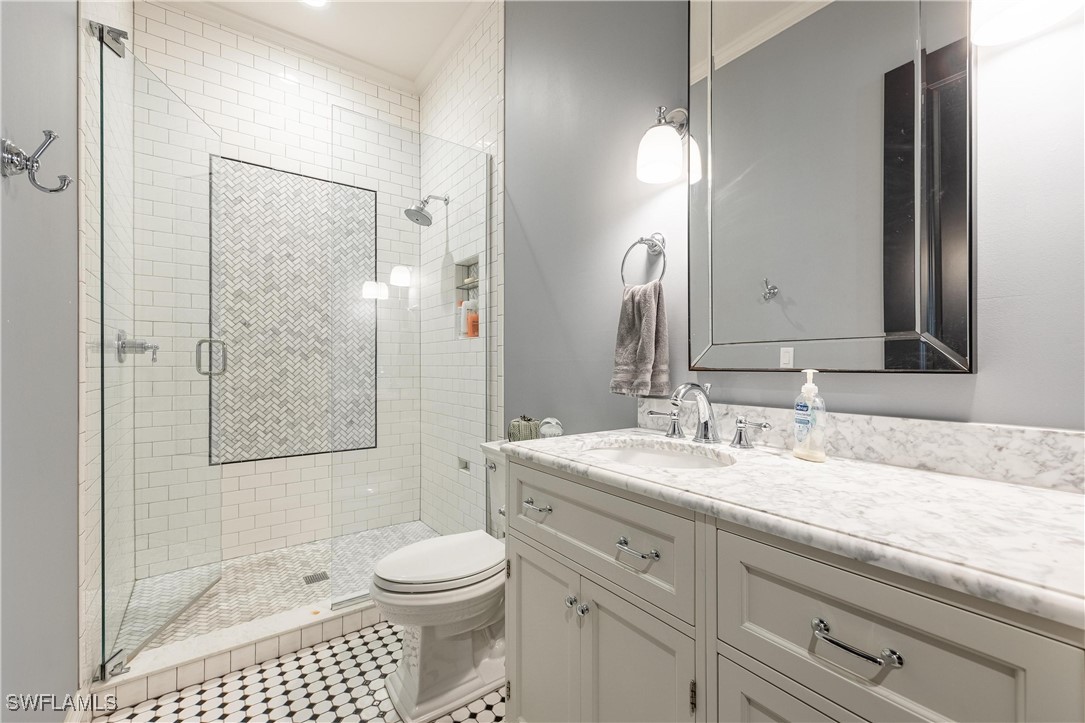 1135 Firebrand Court LaBelle, FL 33935 - Photo 28 of 45 a bathroom with a granite countertop sink toilet a mirror a vanity and shower