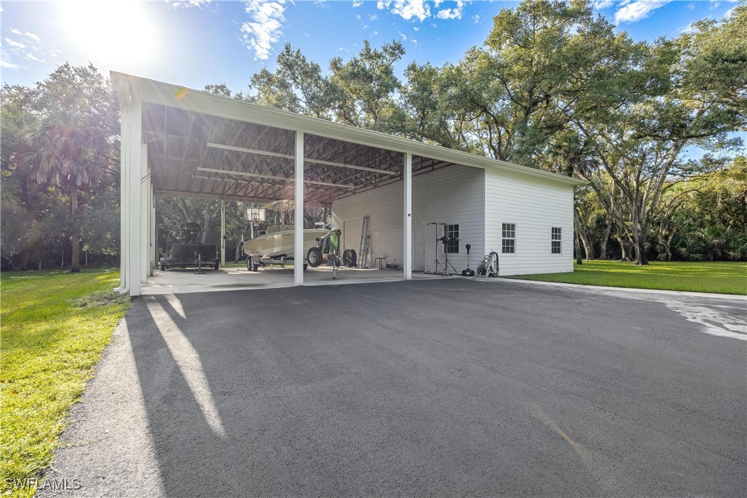 1135 Firebrand Court LaBelle, FL 33935 - Photo 38 of 45 a view of an house with backyard and bushes