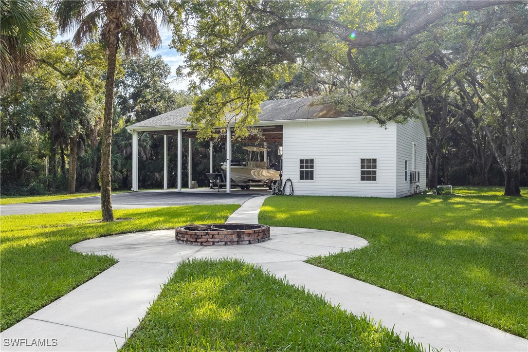 1135 Firebrand Court LaBelle, FL 33935 - Photo 39 of 45 a view of swimming pool with lawn chairs and large trees