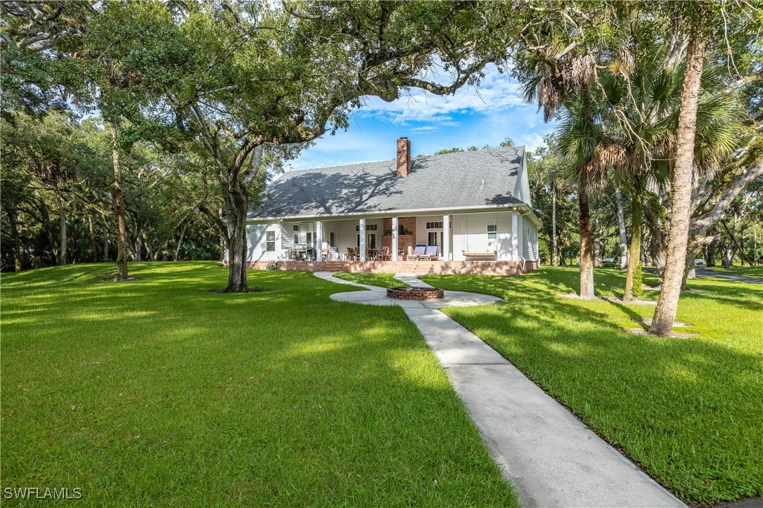 1135 Firebrand Court LaBelle, FL 33935 - Photo 41 of 45 a front view of a house with a yard table and chairs