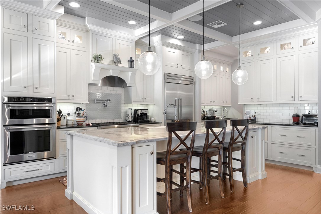 1135 Firebrand Court LaBelle, FL 33935 - Photo 9 of 45 a kitchen with stainless steel appliances granite countertop a stove a refrigerator a oven a sink with a dining table and chairs