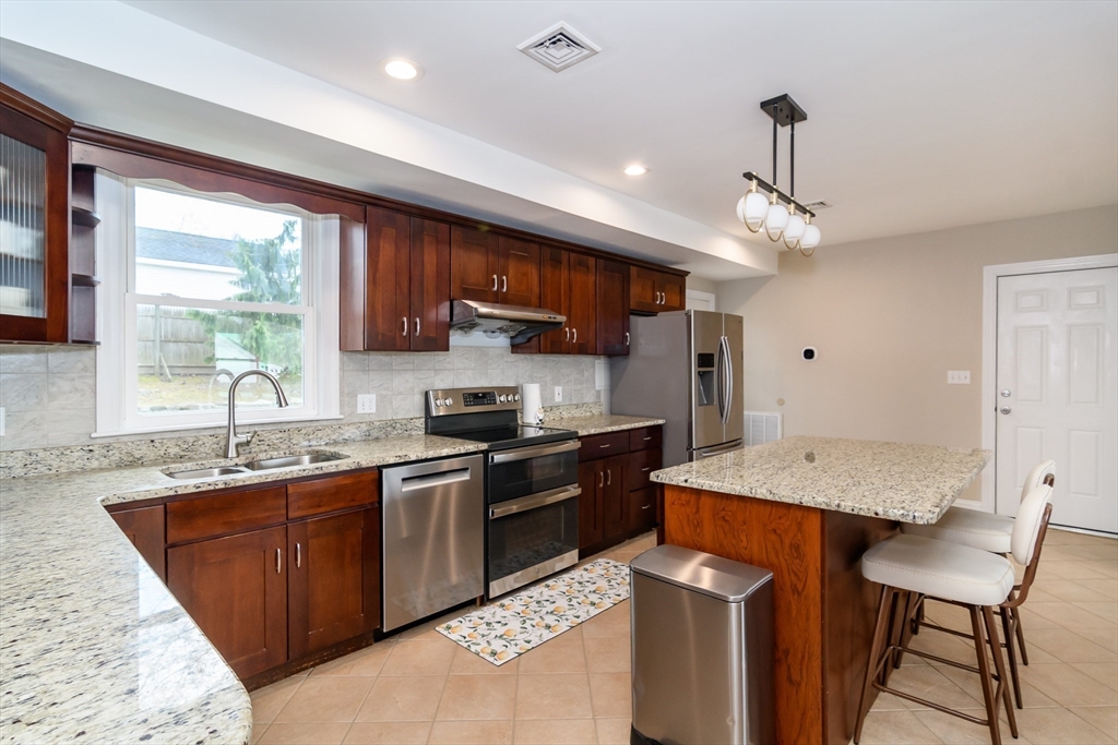 3 Leighton Street Natick, MA 01760 - Photo 5 of 31 a kitchen with stainless steel appliances granite countertop a sink stove and refrigerator