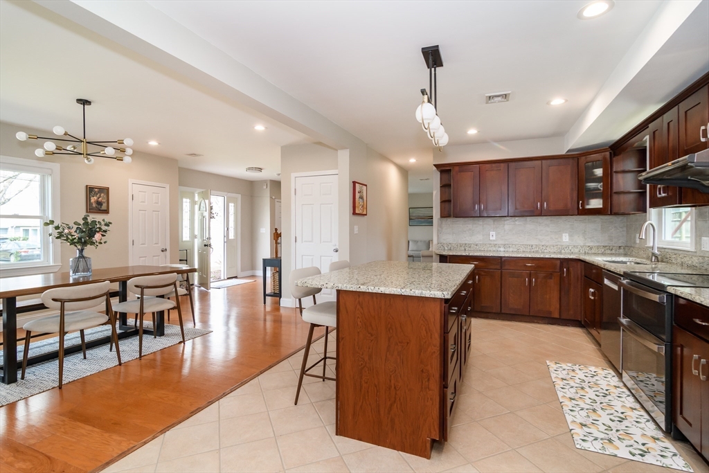 3 Leighton Street Natick, MA 01760 - Photo 6 of 31 a large kitchen with kitchen island a island a stove a sink a dining table and chairs