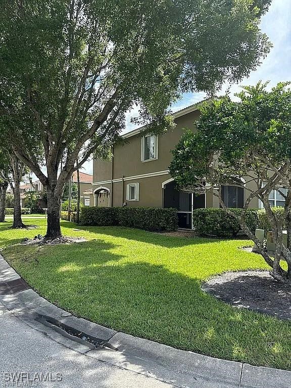 17619 Brickstone Loop Fort Myers, FL 33967 - Photo 5 of 38 a front view of a house with a yard and trees