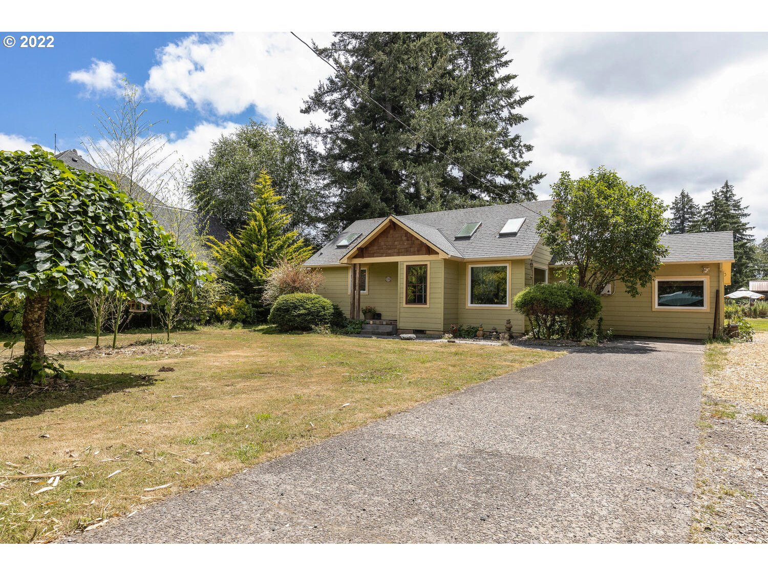 a front view of house with yard and trees in the background