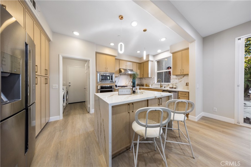 15525 Bonsai Way Tustin, CA 92782 - Photo 14 of 40 a kitchen with kitchen island a sink stove and refrigerator