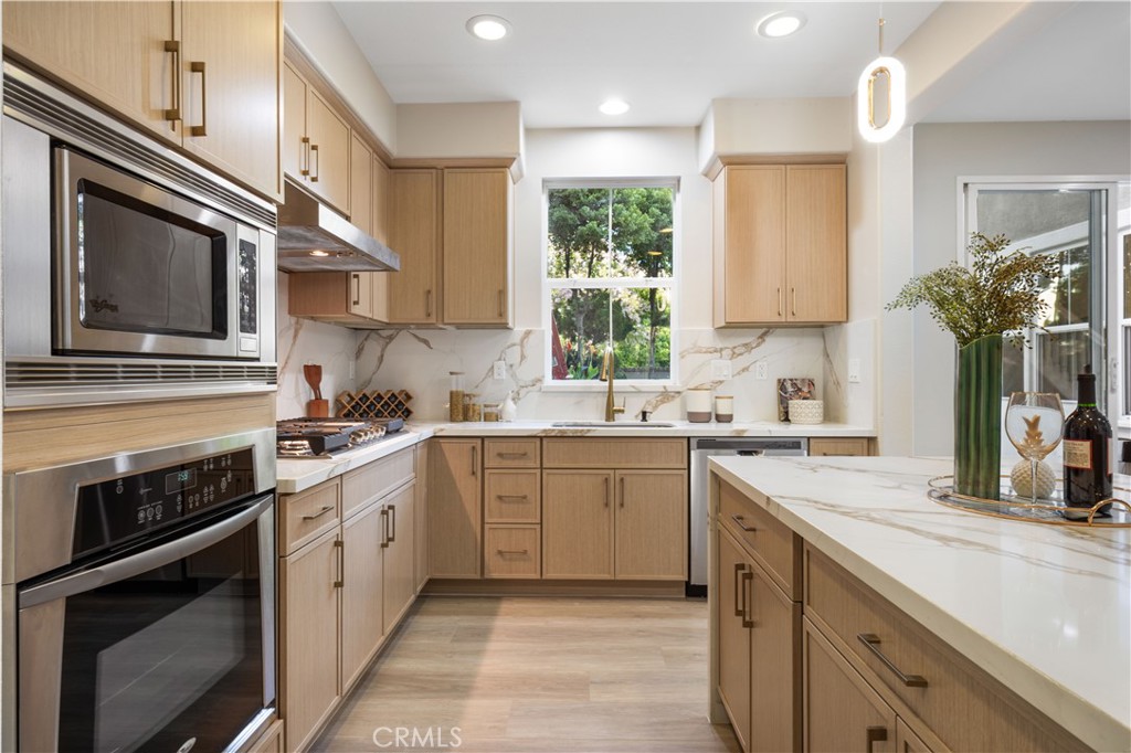 15525 Bonsai Way Tustin, CA 92782 - Photo 18 of 40 a kitchen with a sink stove and microwave