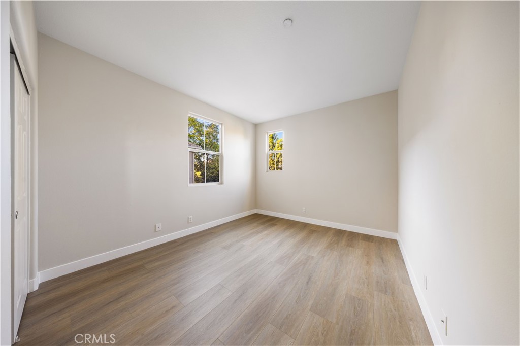 15525 Bonsai Way Tustin, CA 92782 - Photo 20 of 40 an empty room with wooden floor and windows