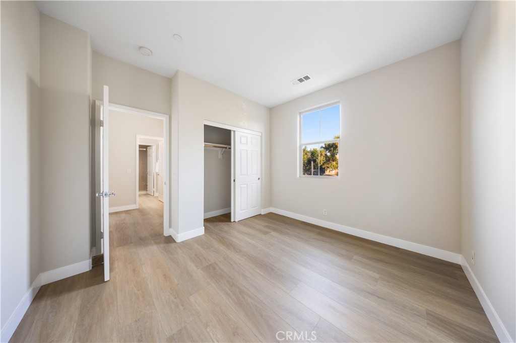 15525 Bonsai Way Tustin, CA 92782 - Photo 23 of 40 an empty room with wooden floor & windows