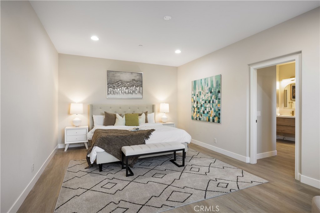 15525 Bonsai Way Tustin, CA 92782 - Photo 30 of 40 a spacious bedroom with a bed and a table in it