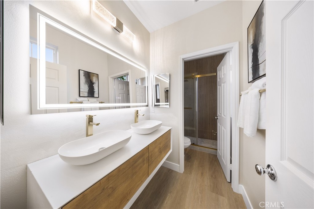 15525 Bonsai Way Tustin, CA 92782 - Photo 35 of 40 a en suite bathroom with a granite countertop sink and a mirror