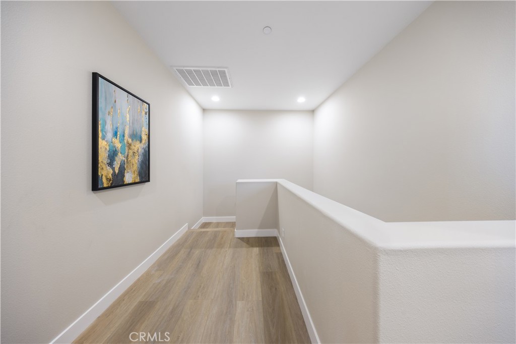 15525 Bonsai Way Tustin, CA 92782 - Photo 36 of 40 a view of hallway with stairs and wooden floor