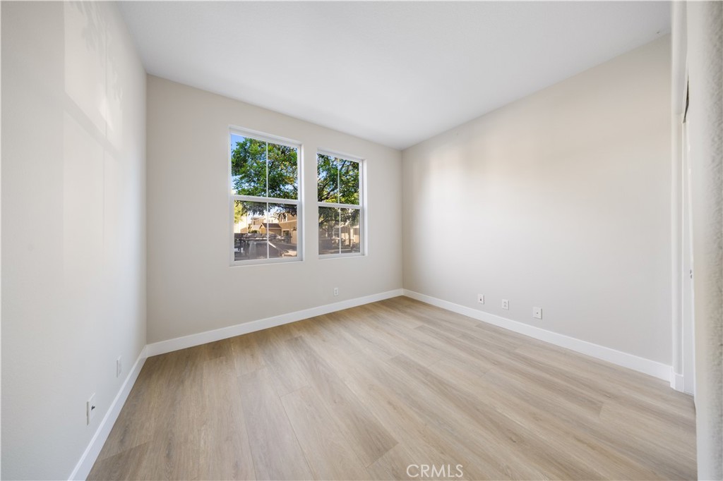 15525 Bonsai Way Tustin, CA 92782 - Photo 5 of 40 an empty room with wooden floor and windows