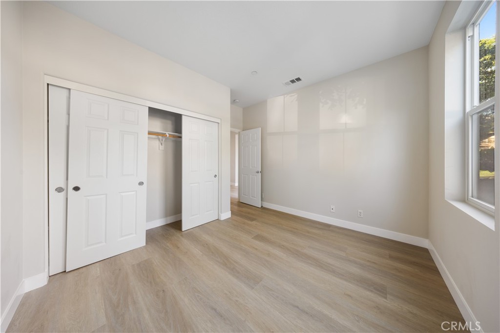 15525 Bonsai Way Tustin, CA 92782 - Photo 6 of 40 a view of an empty room with wooden floor and a window