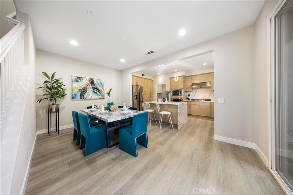 15525 Bonsai Way Tustin, CA 92782 - Photo 8 of 40 a living room with furniture a wooden floor and a kitchen