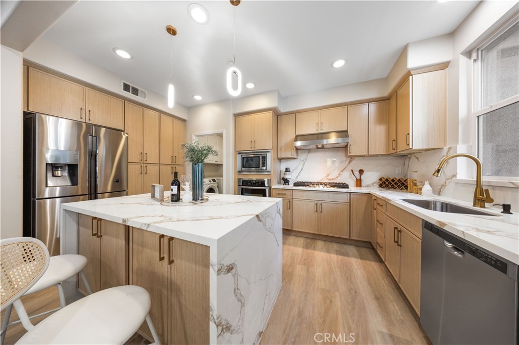 15525 Bonsai Way Tustin, CA 92782 - Photo 9 of 40 a kitchen with a sink a stove a refrigerator and cabinets