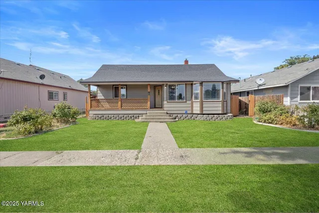 a front view of a house with a yard and trees