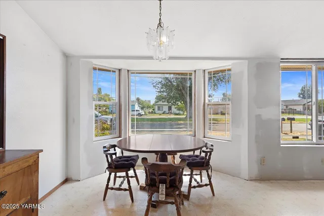 a dining room with furniture a chandelier and wooden floor
