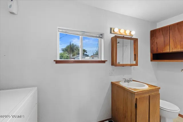 a bathroom with a toilet a sink and a window