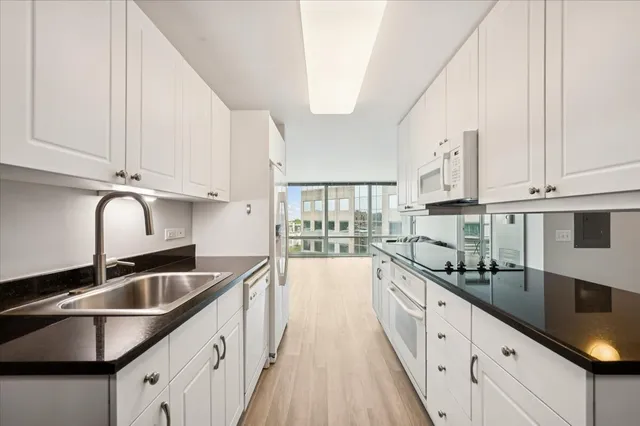 a kitchen with granite countertop a sink and cabinets