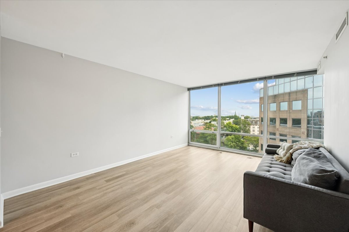 800 Elgin Road, Unit 1013 Evanston, IL 60201 - Photo 9 of 25 a living room with furniture and a floor to ceiling window
