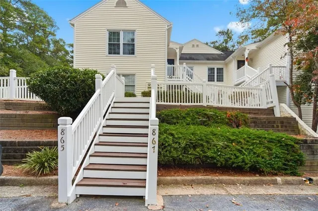 a view of a house with wooden fence and potted plants