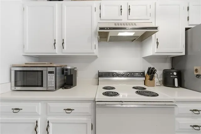 a kitchen with a white cabinets and white appliances