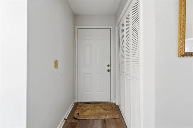 a view of a hallway with wooden floor and a dining room