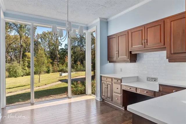 a kitchen with stainless steel appliances granite countertop a refrigerator a stove and a sink with wooden cabinets