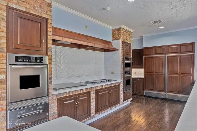 a kitchen with stainless steel appliances granite countertop a stove a sink and a refrigerator