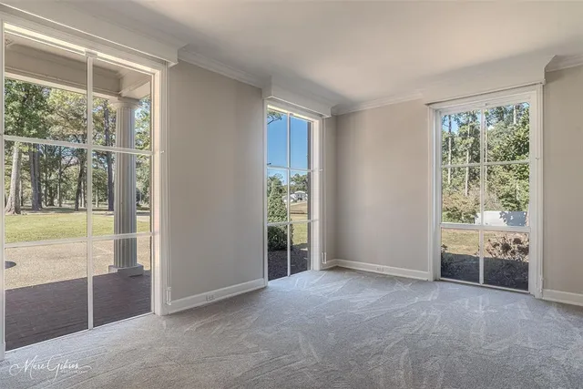 a view of an empty room with glass door and balcony