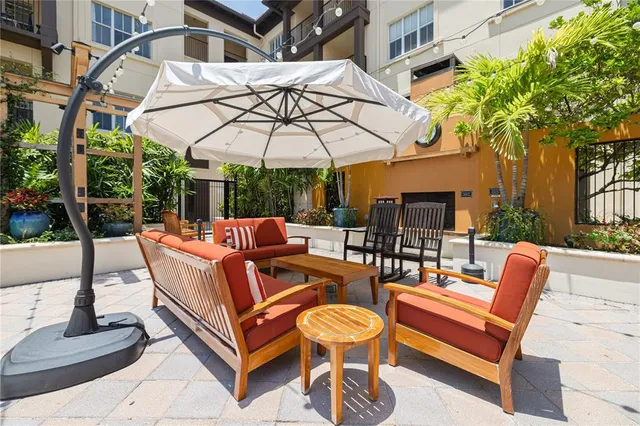 a view of a patio with a table and chairs under an umbrella